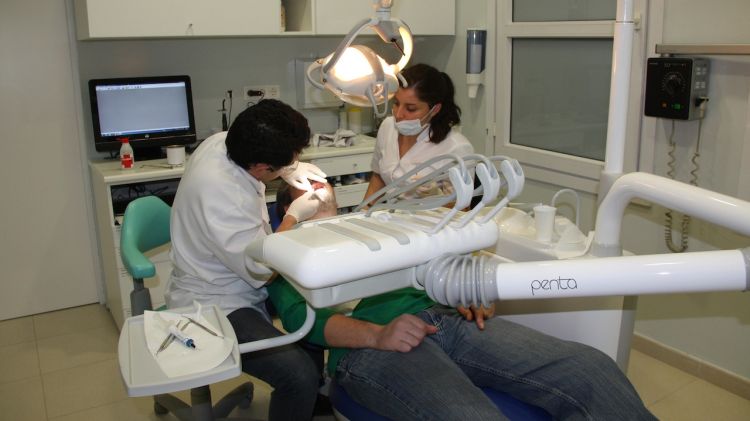 Un dels dentistes que col·laboren desinteressadament a la clínia atenent a un pacient (arxiu) © ACN
