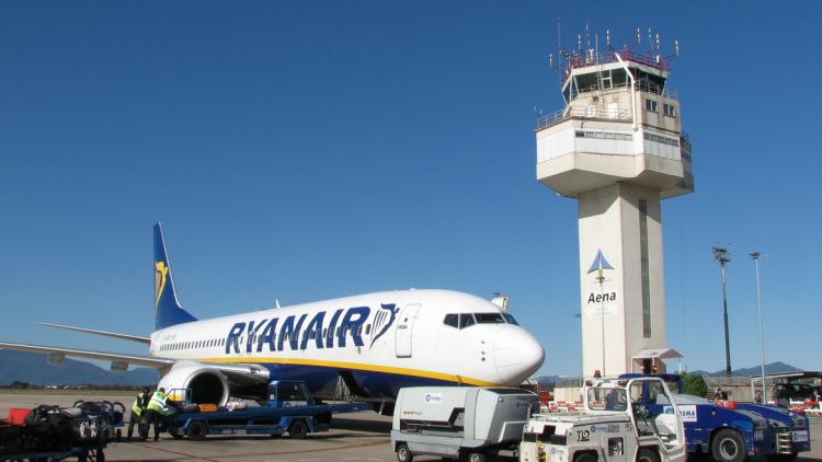 Un avió davant la torre de control de l'aeroport de Girona