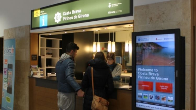Dos turistes demanant informació a l'Oficina de Turisme de l'Aeroport de Girona  © ACN