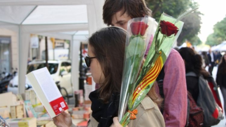 Una parella de joves que han matinat per comprar les primeres roses i llibres © ACN