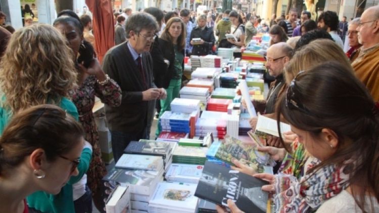 Gent remenant i comprant llibres a una de les parades de la Rambla de Girona © ACN