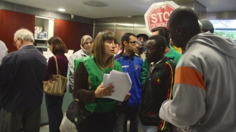 La portaveu de la PAH a Girona, Marta Afuera, parla amb l'afectat, en Demba © ACN