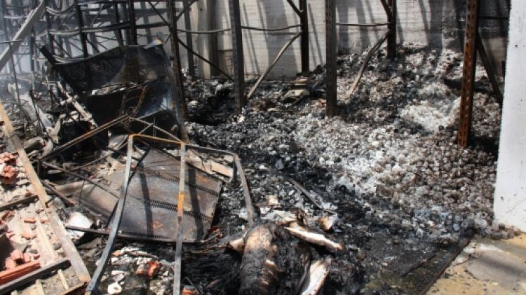 A les dues del migdia, les restes cremades del local encara fumejaven © ACN